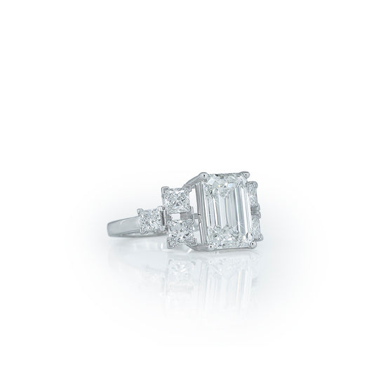 Emerald cut diamond center ring with side diamonds (three-stone or multi-stone ring). Diamlux Fine Jewelry