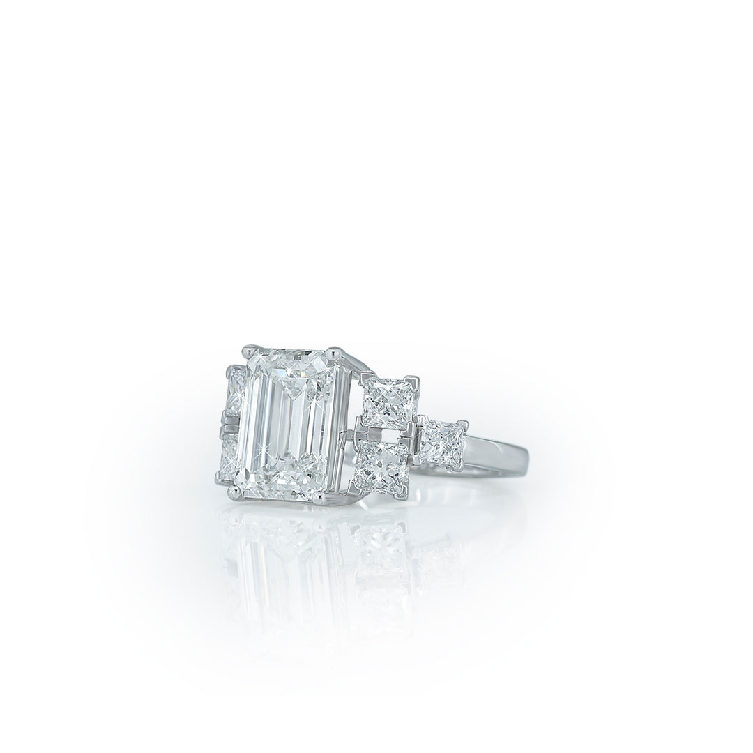Emerald cut diamond center ring with side diamonds (three-stone or multi-stone ring). Diamlux Fine Jewelry